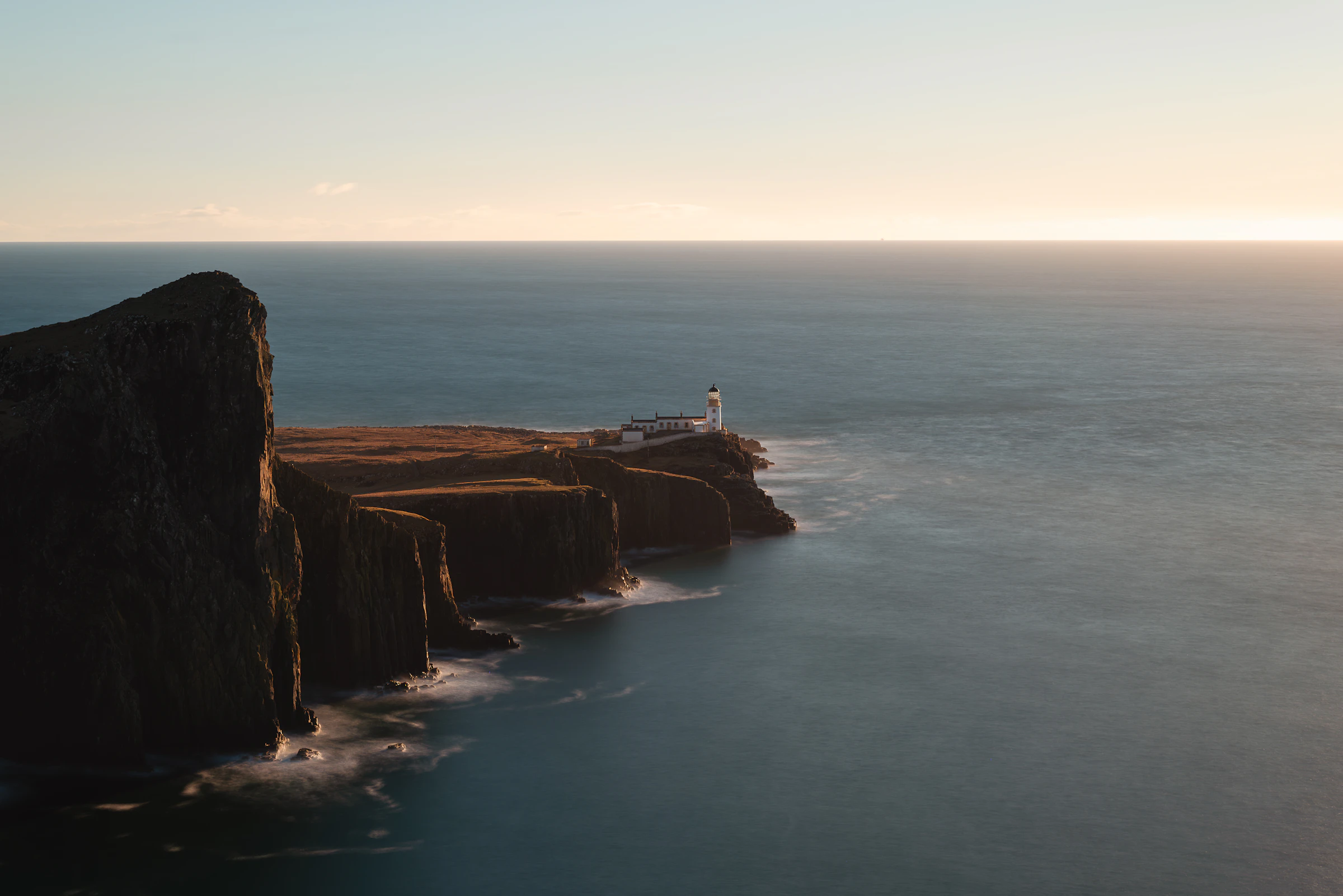 Neist Point lighthouse on its Atlantic headland, Isle of Skye, at sunset