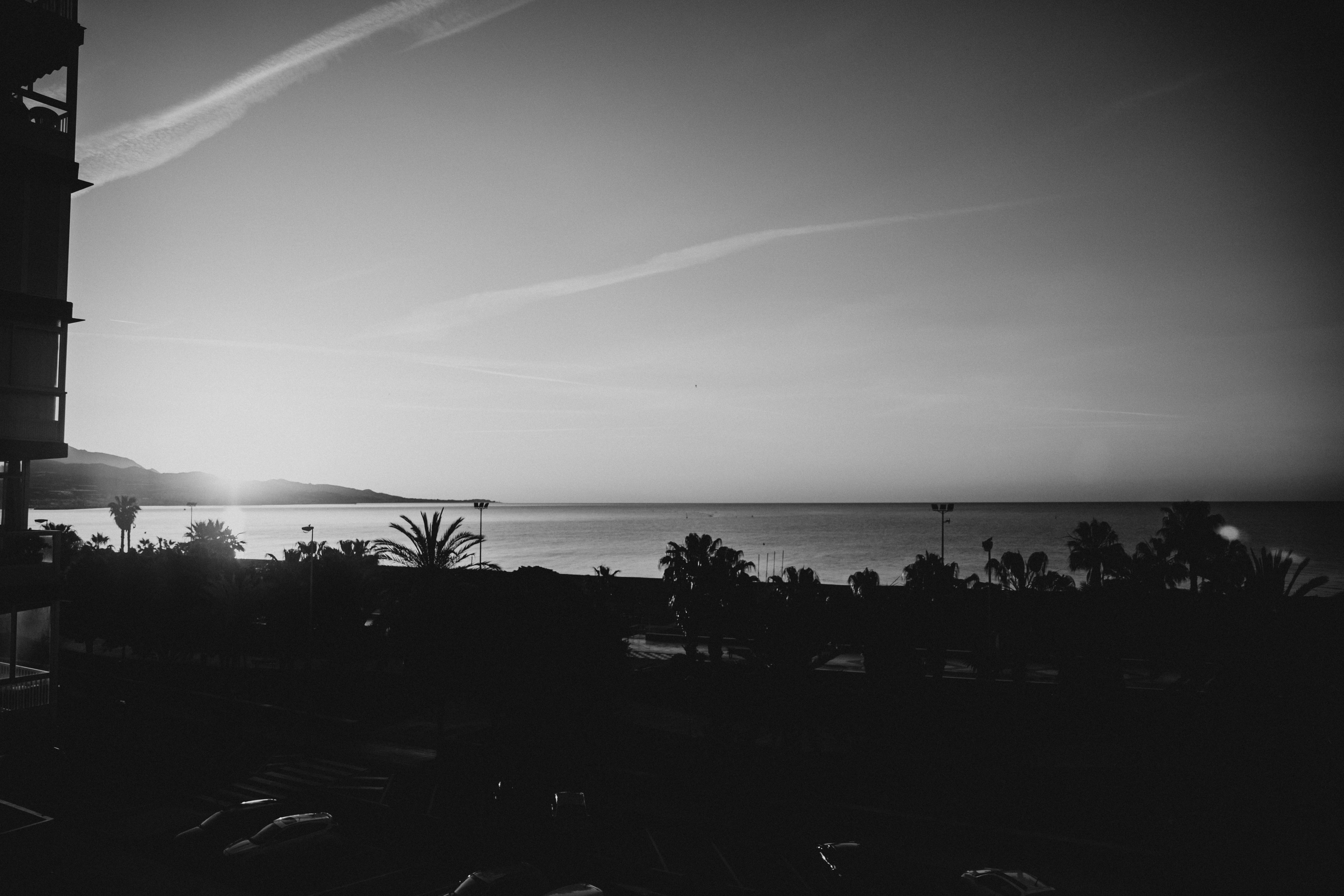 Lever de soleil sur l’océan avec un ciel nuageux.