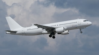 A white airplane is taking off in the sky.