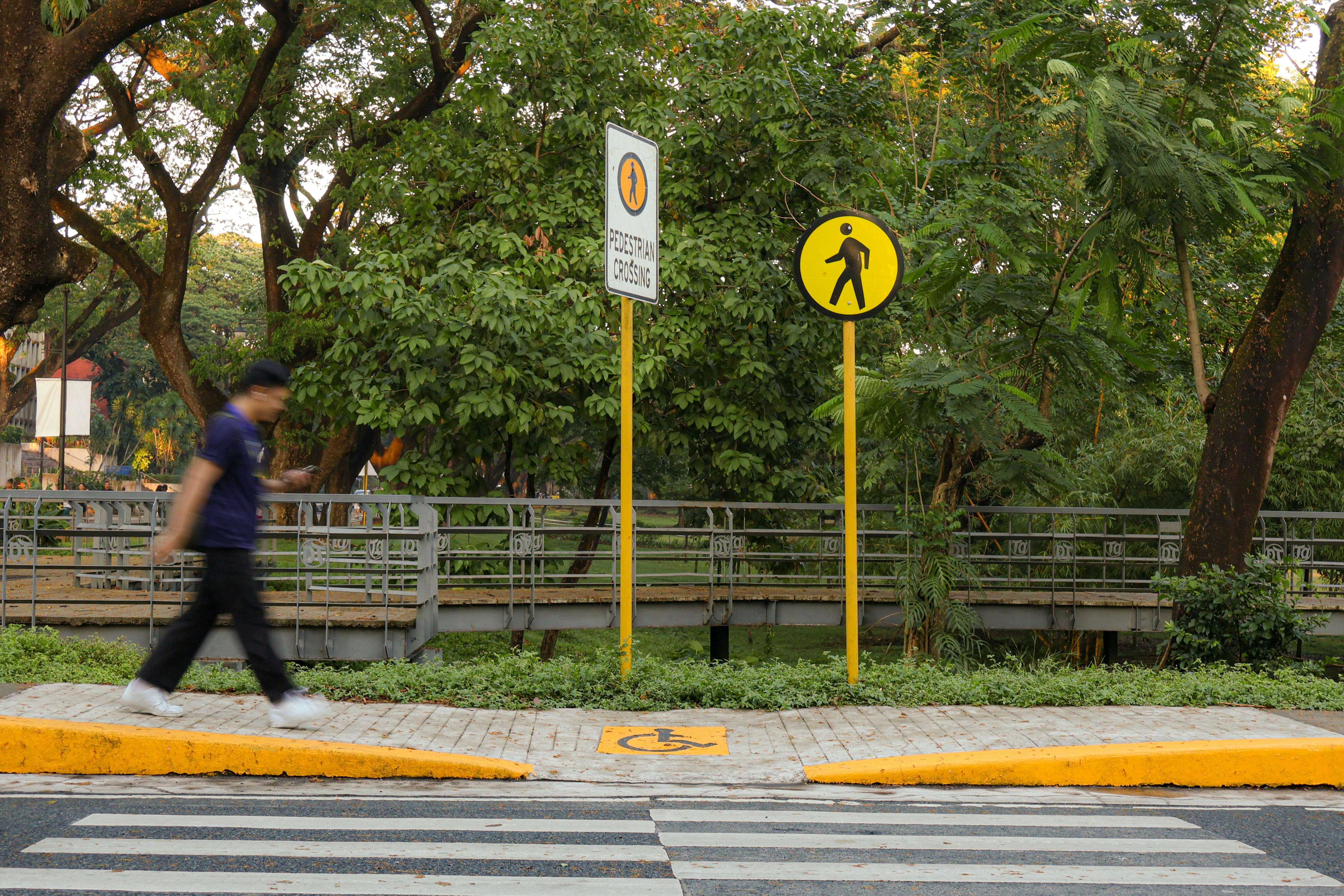 A pedestrian is walking across a crosswalk. photo – Free Road Image on ...
