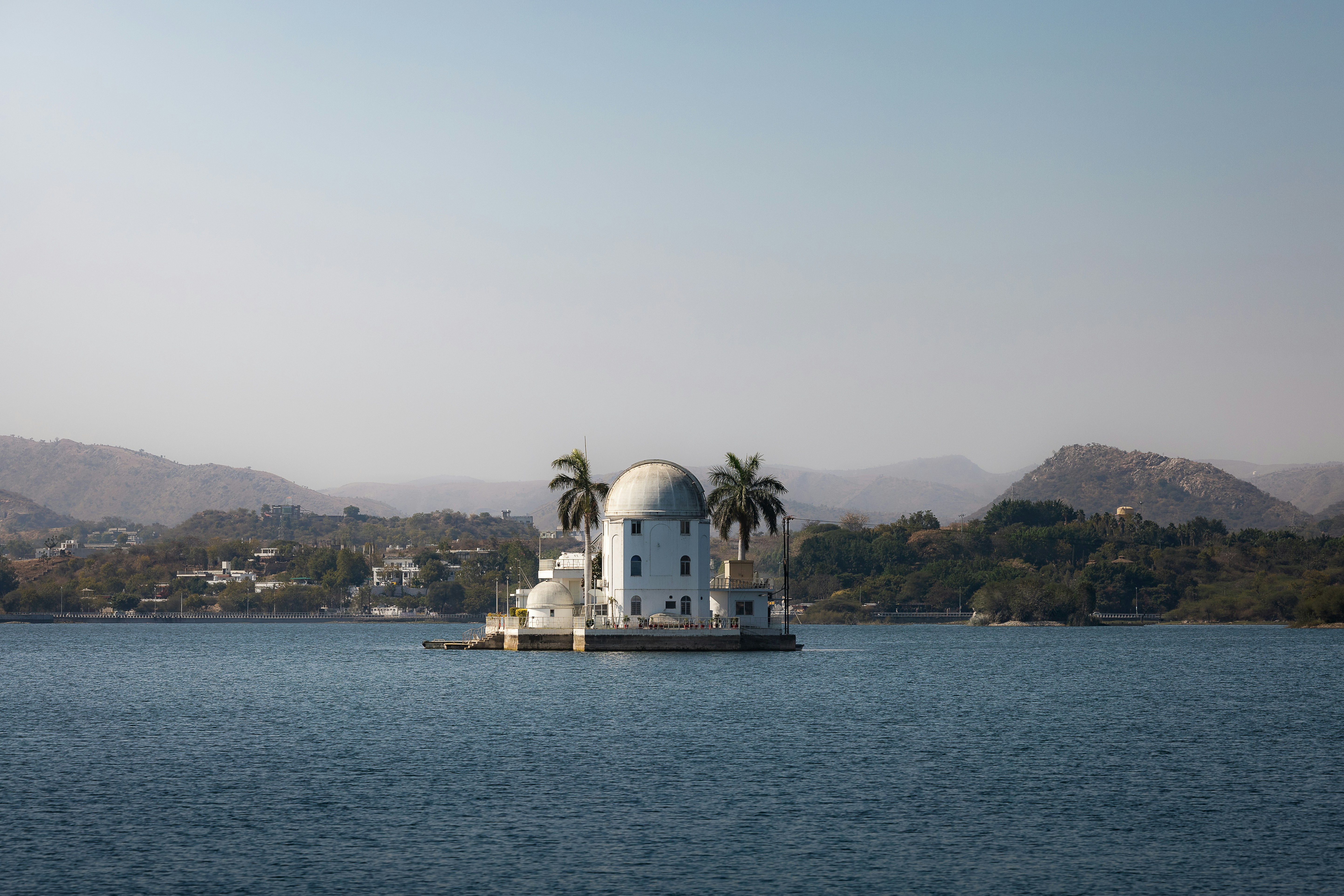 A white building stands on a lake.
