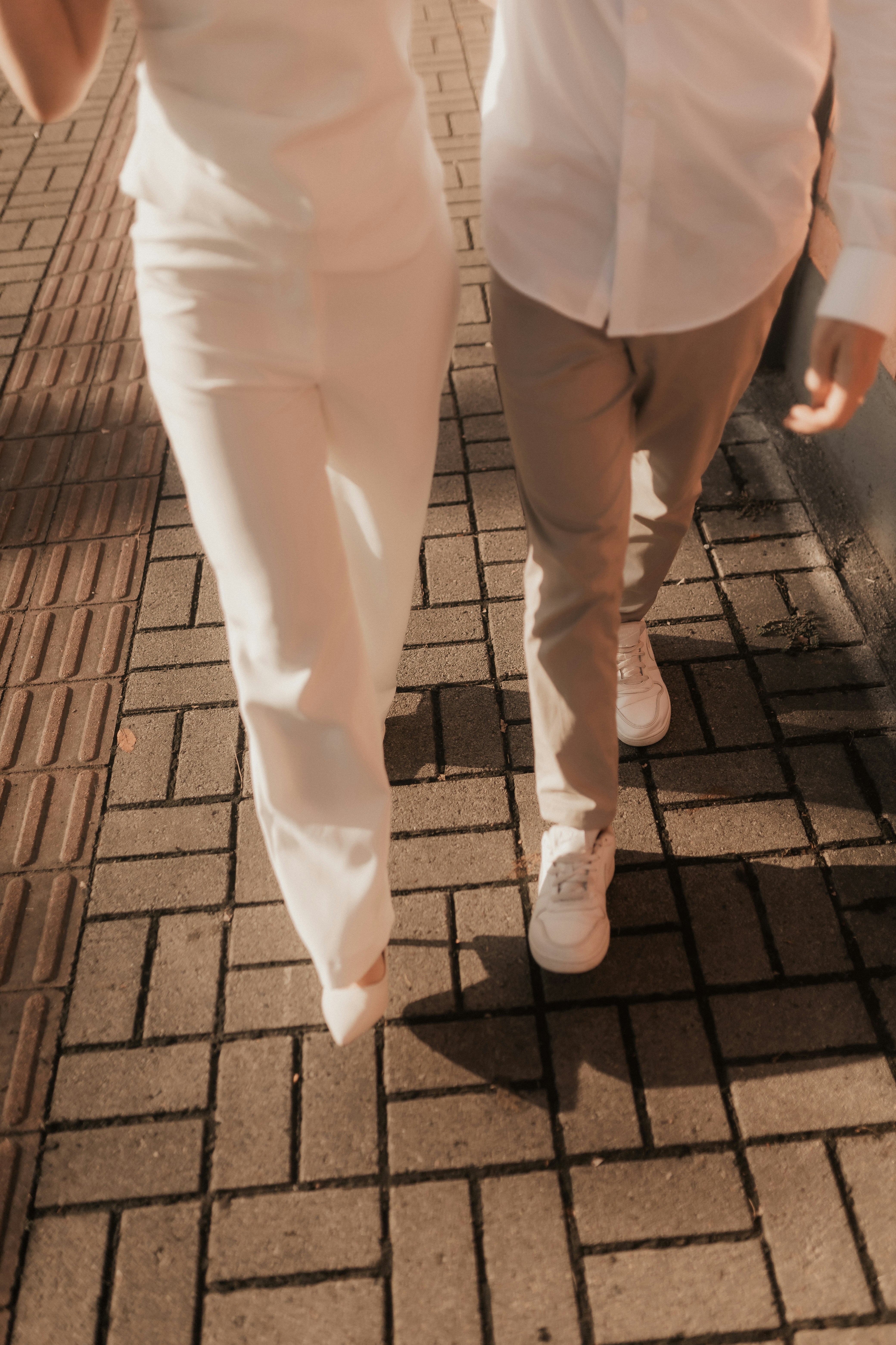 Couple walking on a brick sidewalk together. photo – Free Woman Image ...