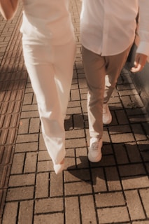 Couple walking on a brick sidewalk together.