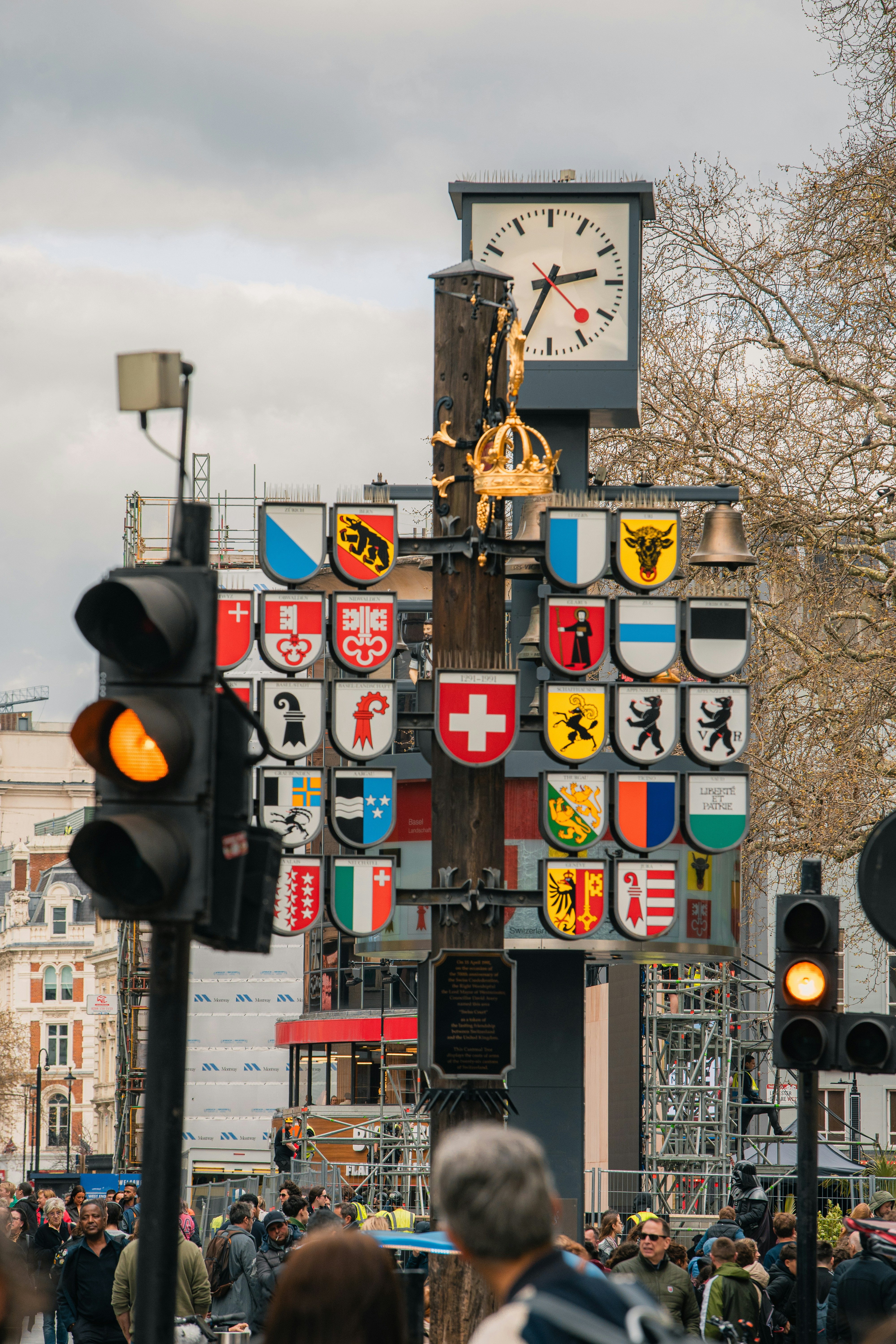 A clock and heraldry decorates a street pole