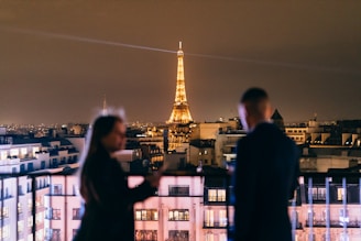 People admire the eiffel tower at night.