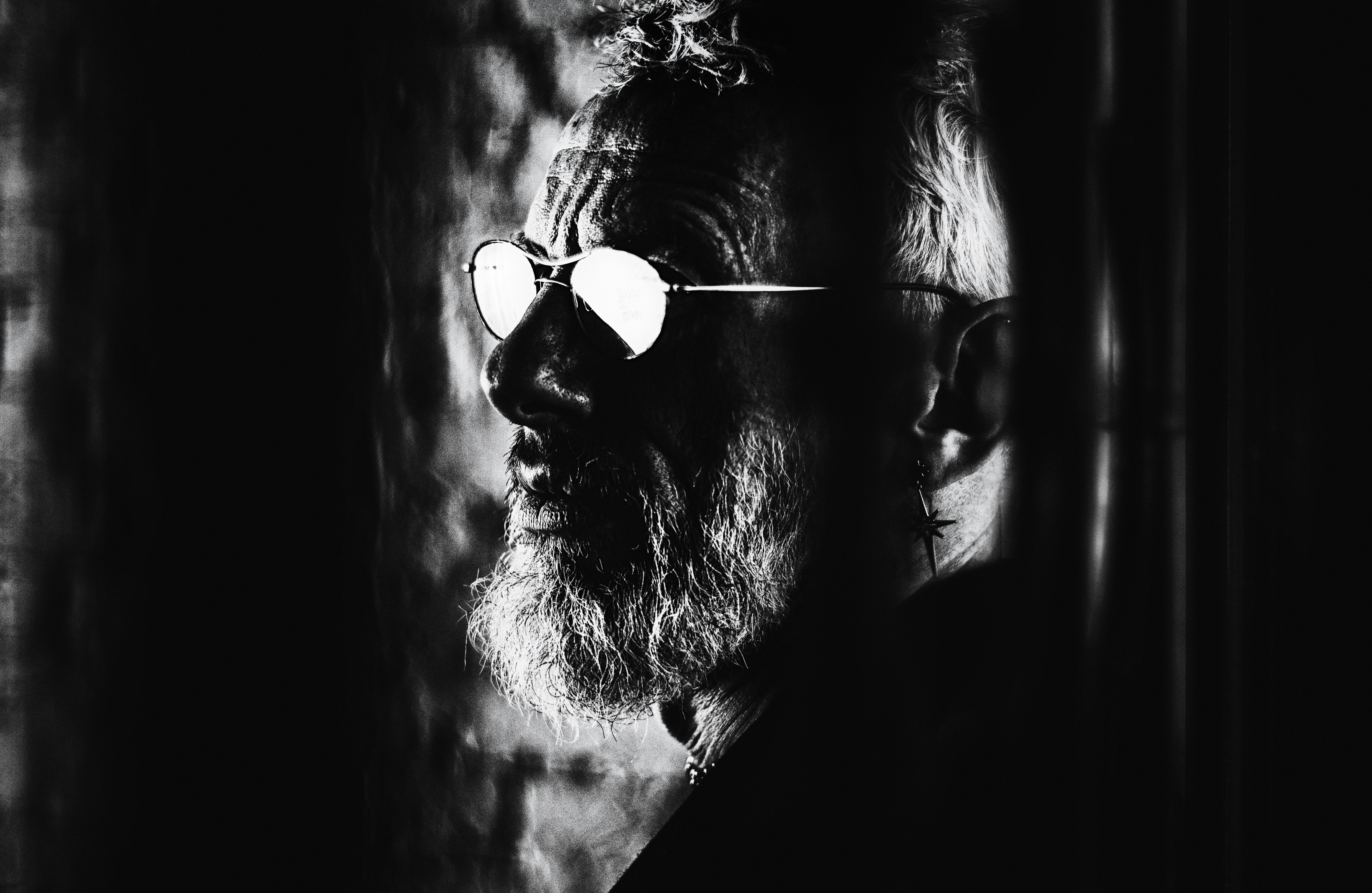 A man wears glasses in shadow.