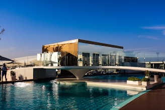 A modern building sits on a beautiful pool.