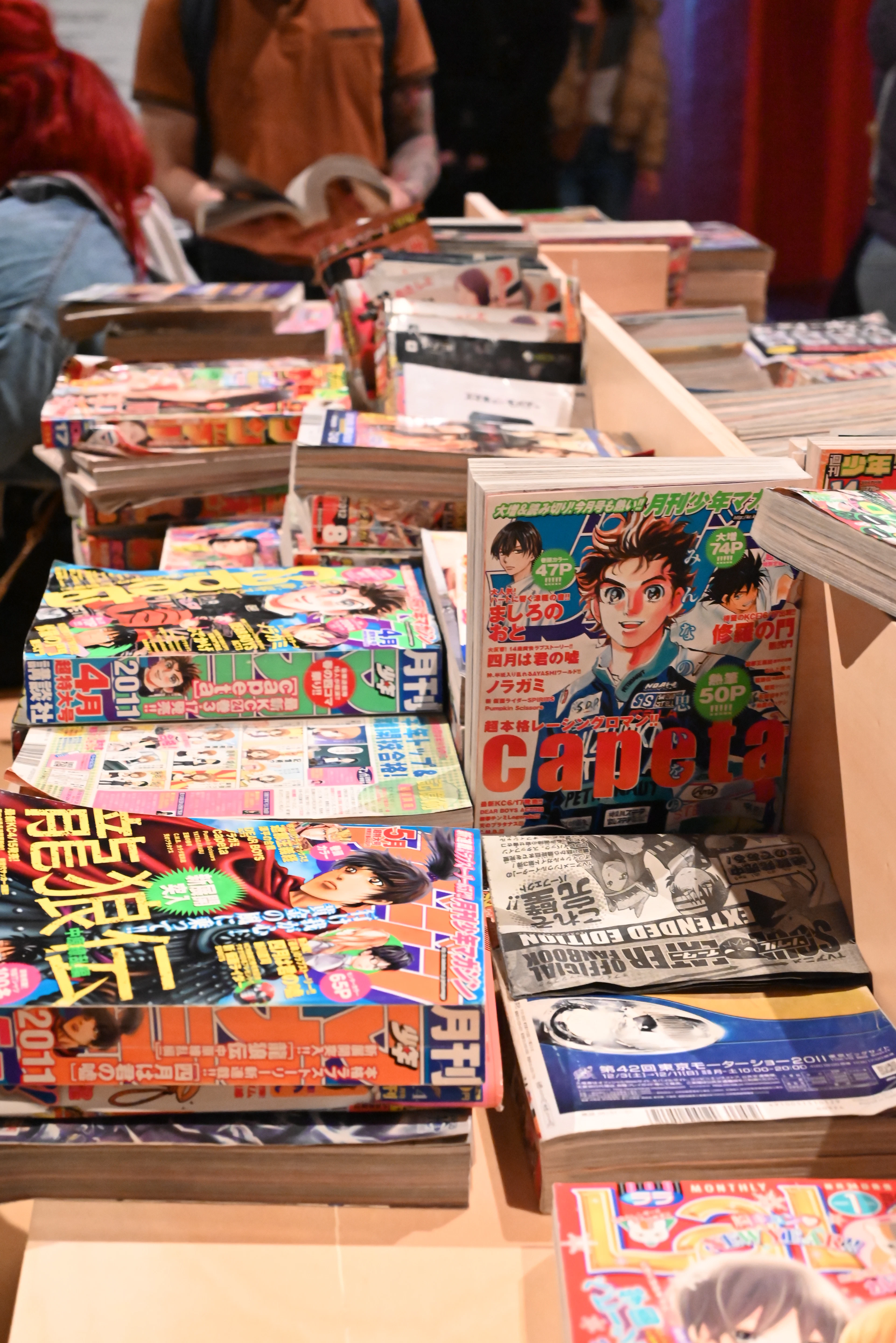 Piles de magazines et de mangas japonais exposés sur un présentoir