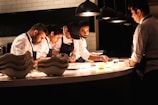 Chefs work diligently in a well-lit kitchen.