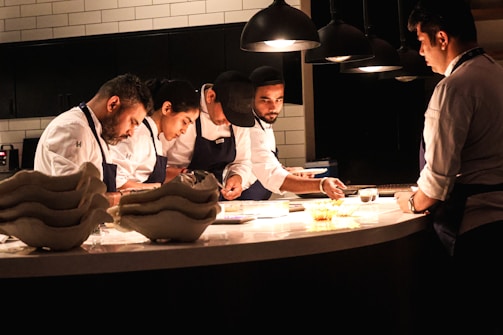 Chefs work diligently in a well-lit kitchen.