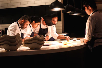 Chefs work diligently in a well-lit kitchen.