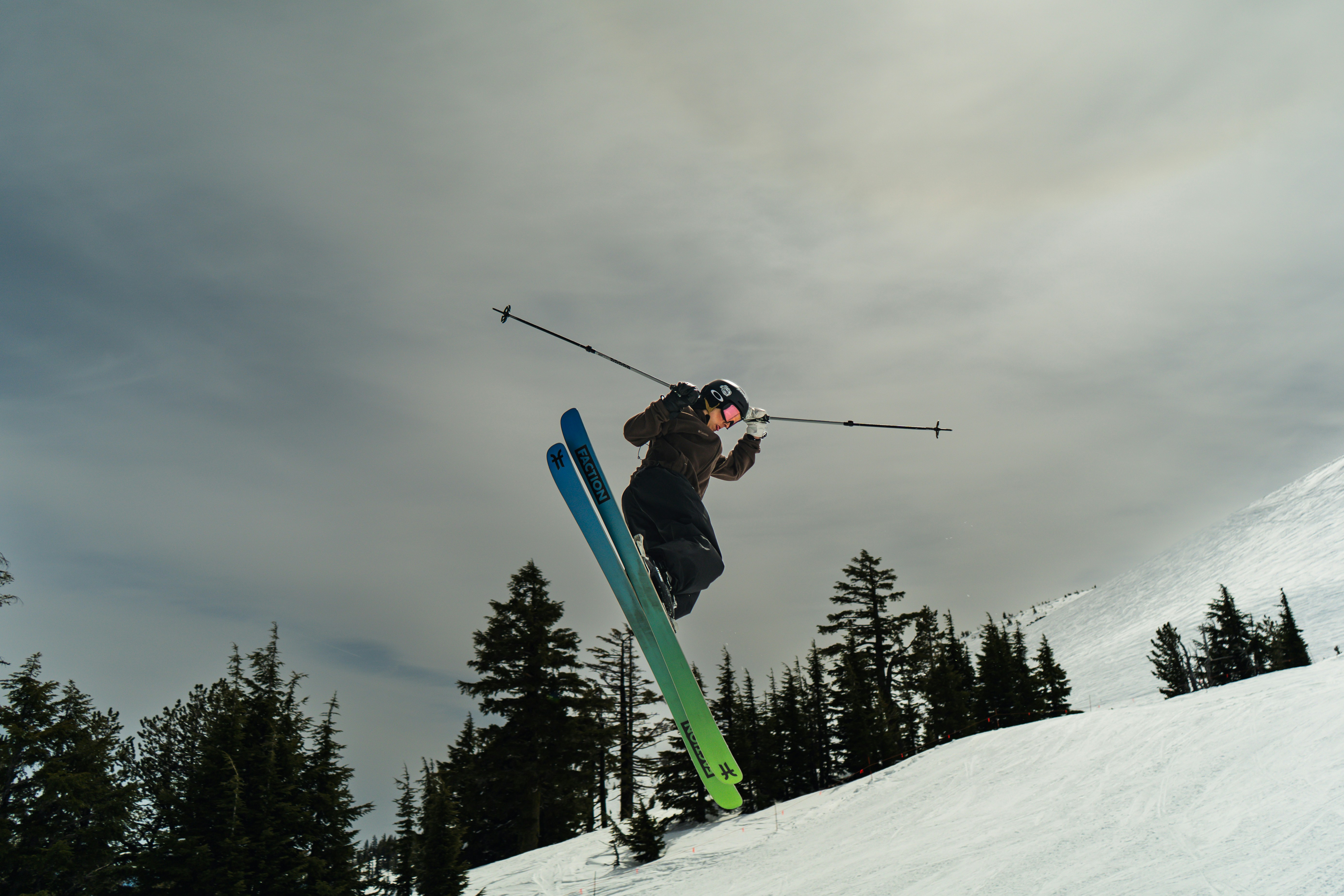 Skier leaps into the air off a snowy slope.