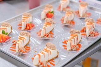 Cheesecake slices arranged on clear plates with decoration.