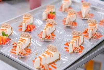 Cheesecake slices arranged on clear plates with decoration.