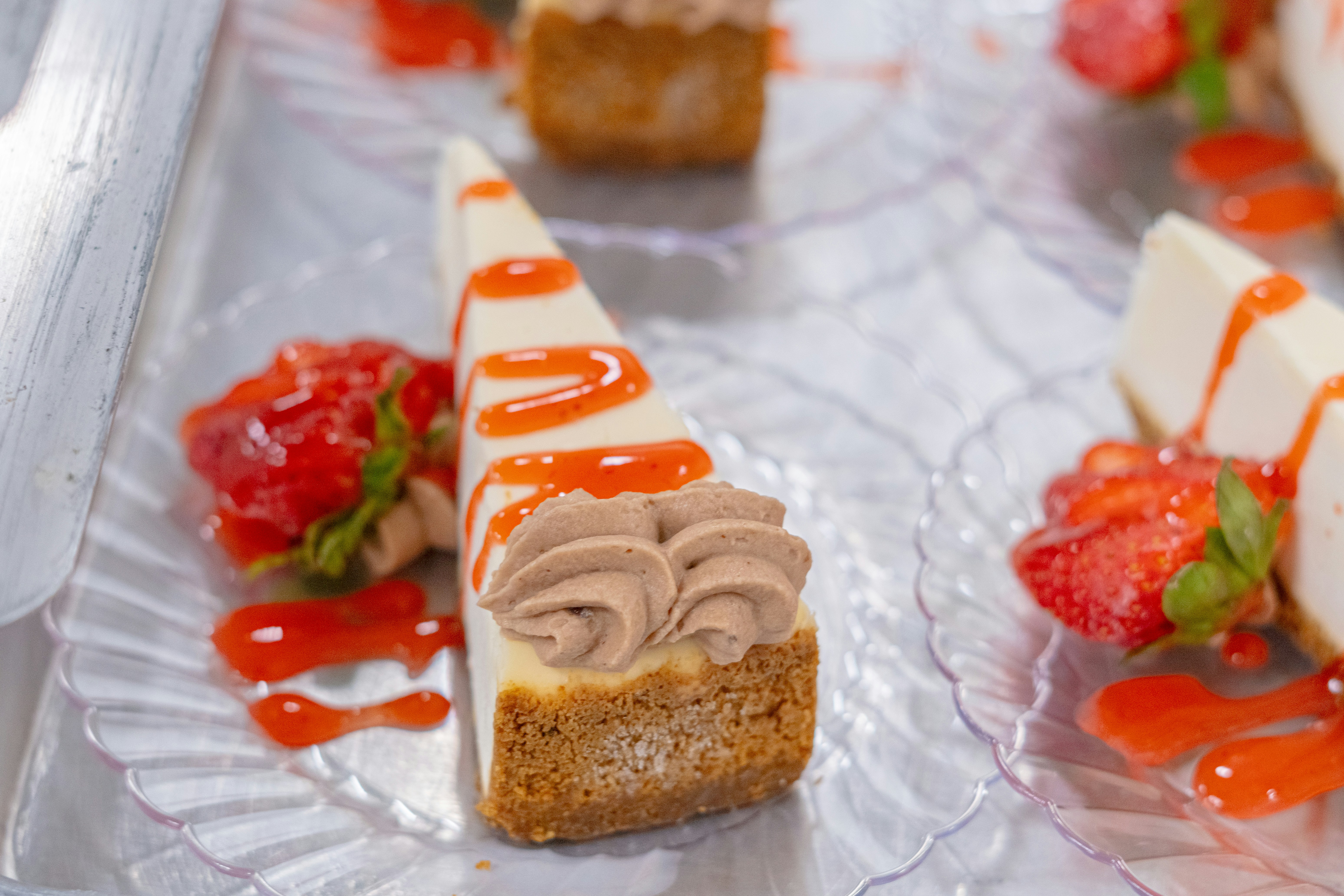 Delicious cheesecake slices with strawberries and sauce.