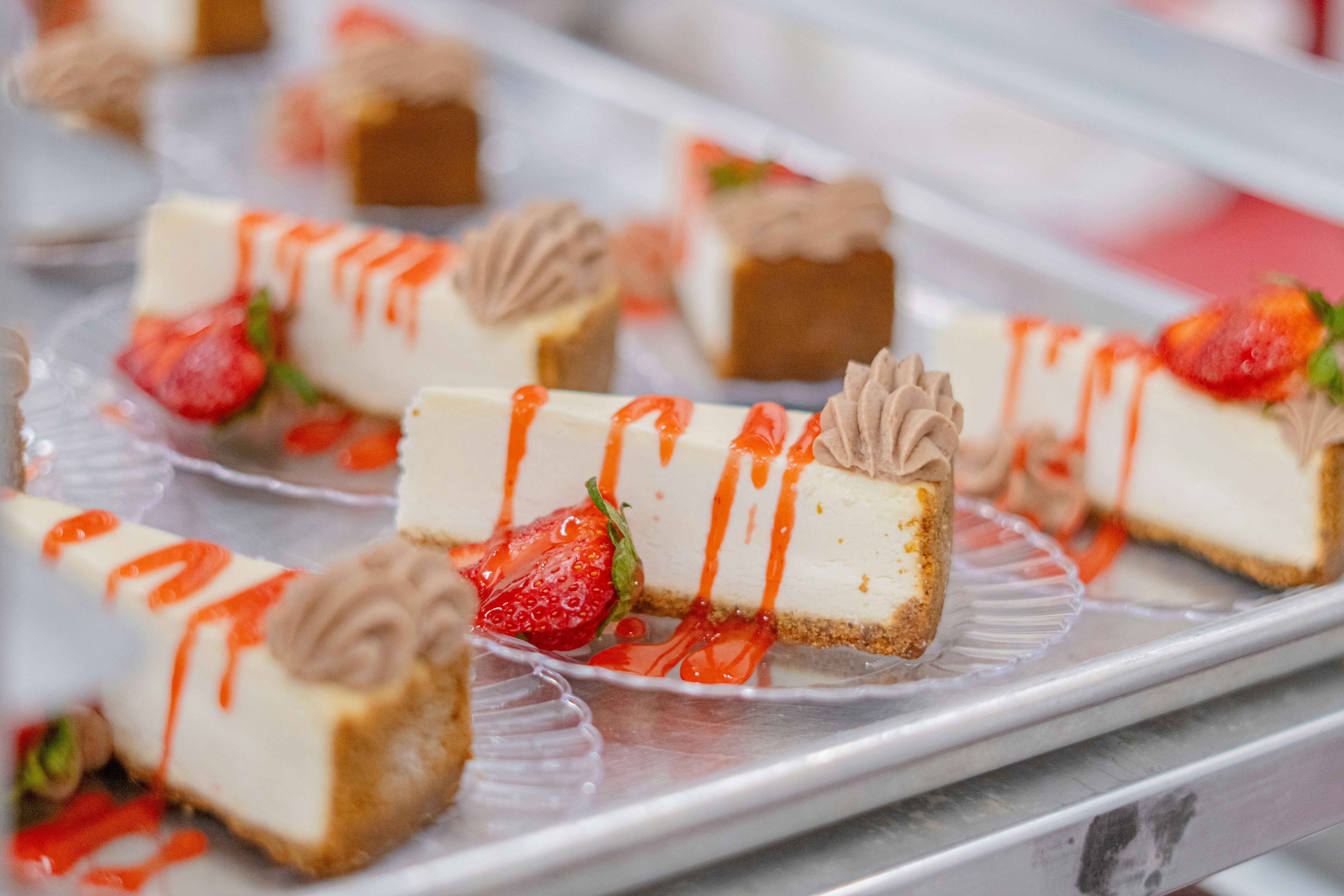 Cheesecake slices with strawberry drizzle and topping