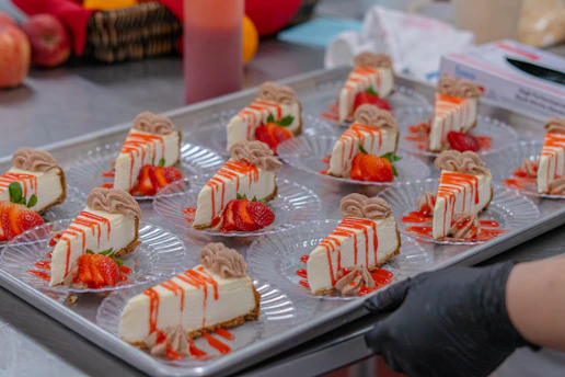 Cheesecake slices are arranged on plates, ready to serve