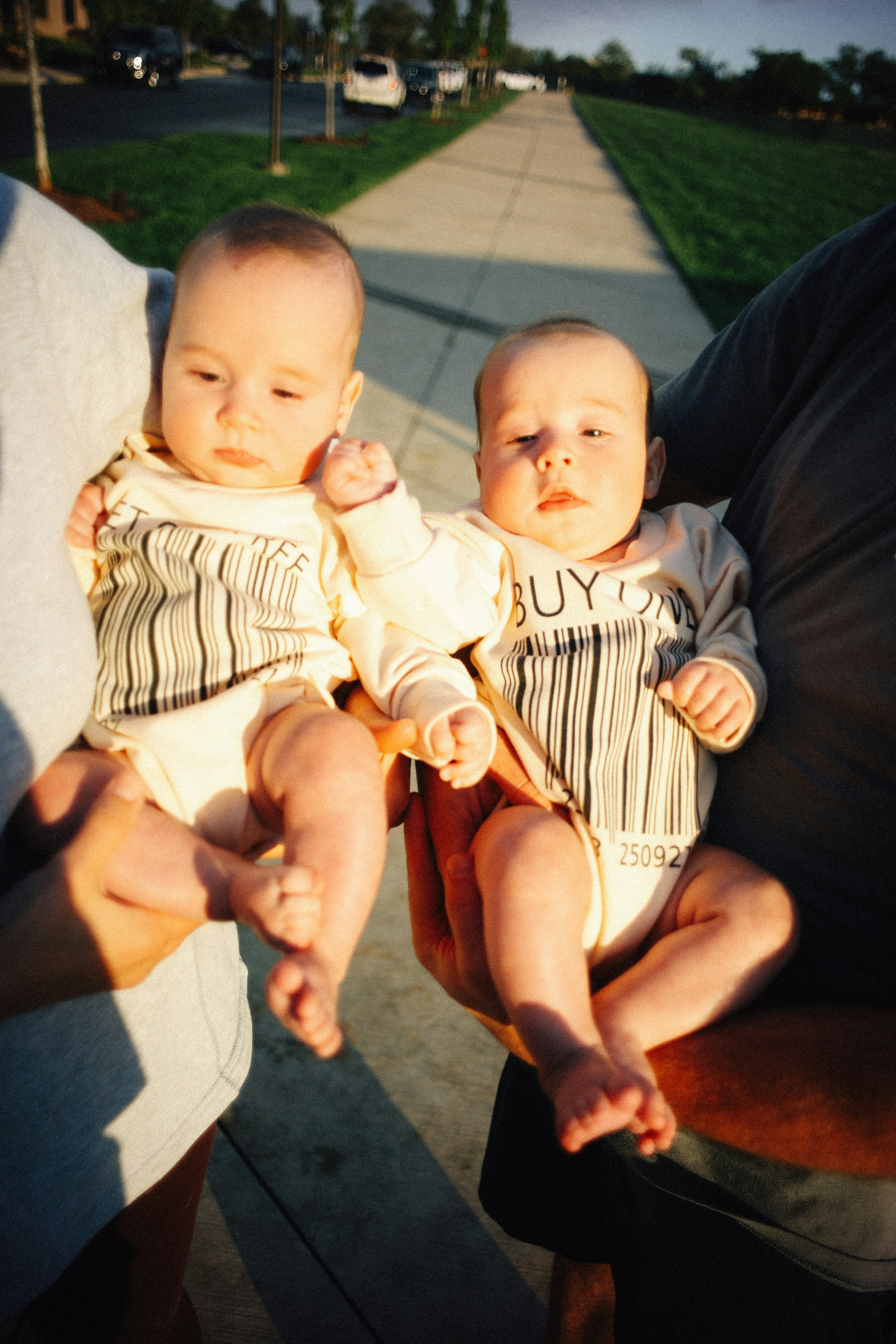 Two babies in matching barcode onesies.