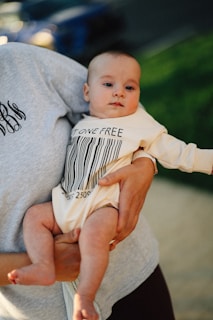 A baby is held while wearing a barcode outfit.