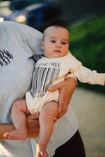 A baby is held while wearing a barcode outfit.