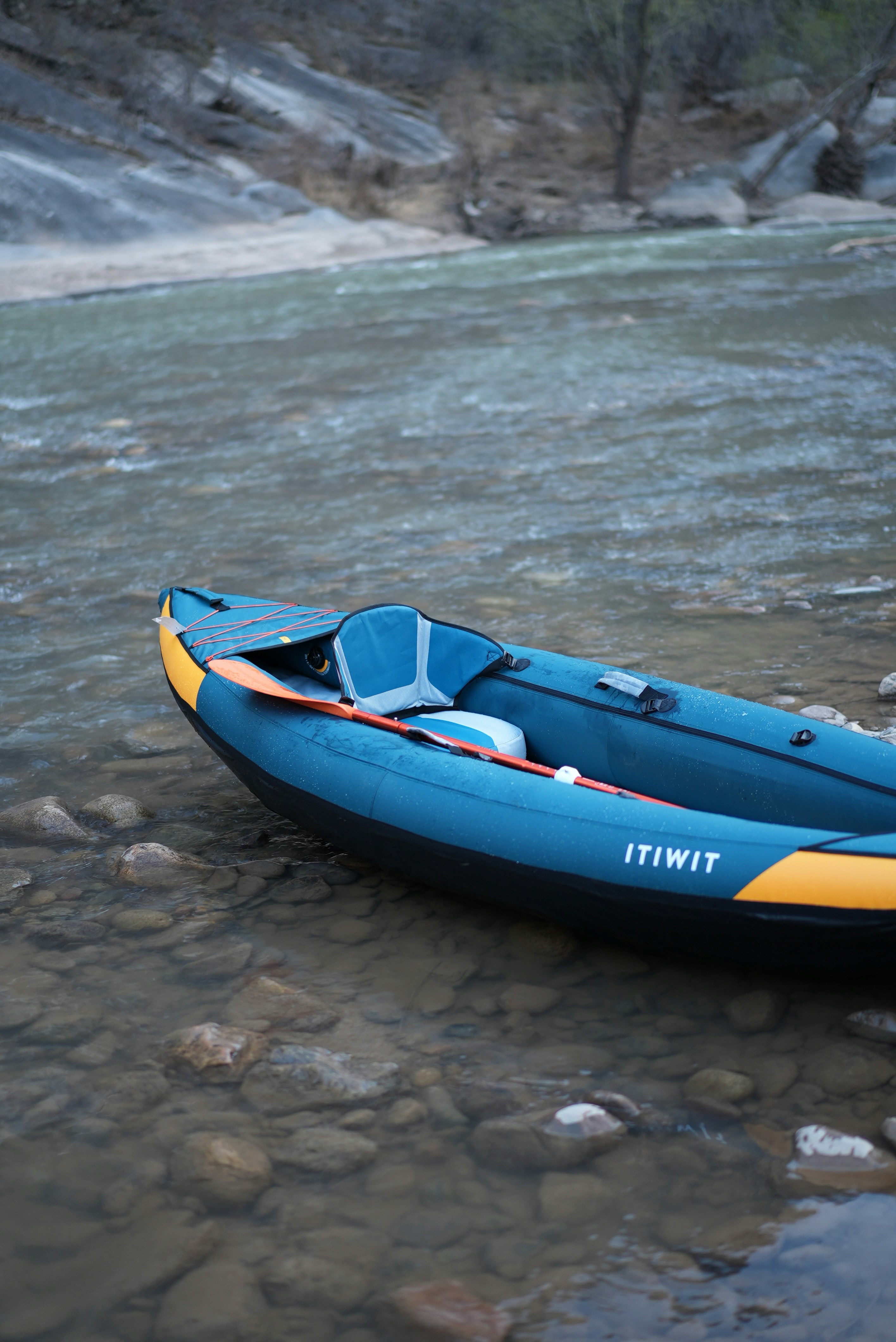 A blue kayak rests on the water's edge
