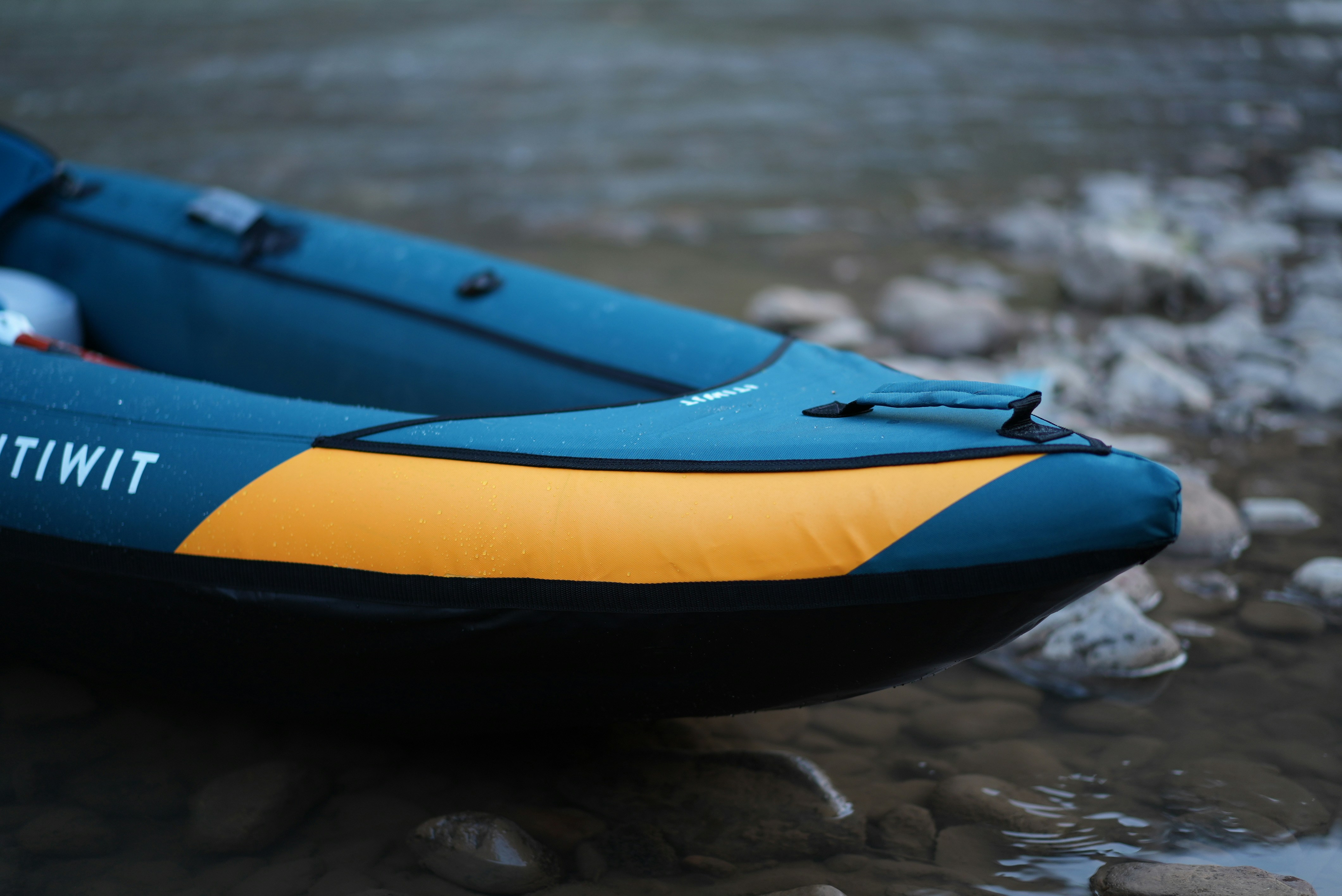 A partially-visible kayak floats on water