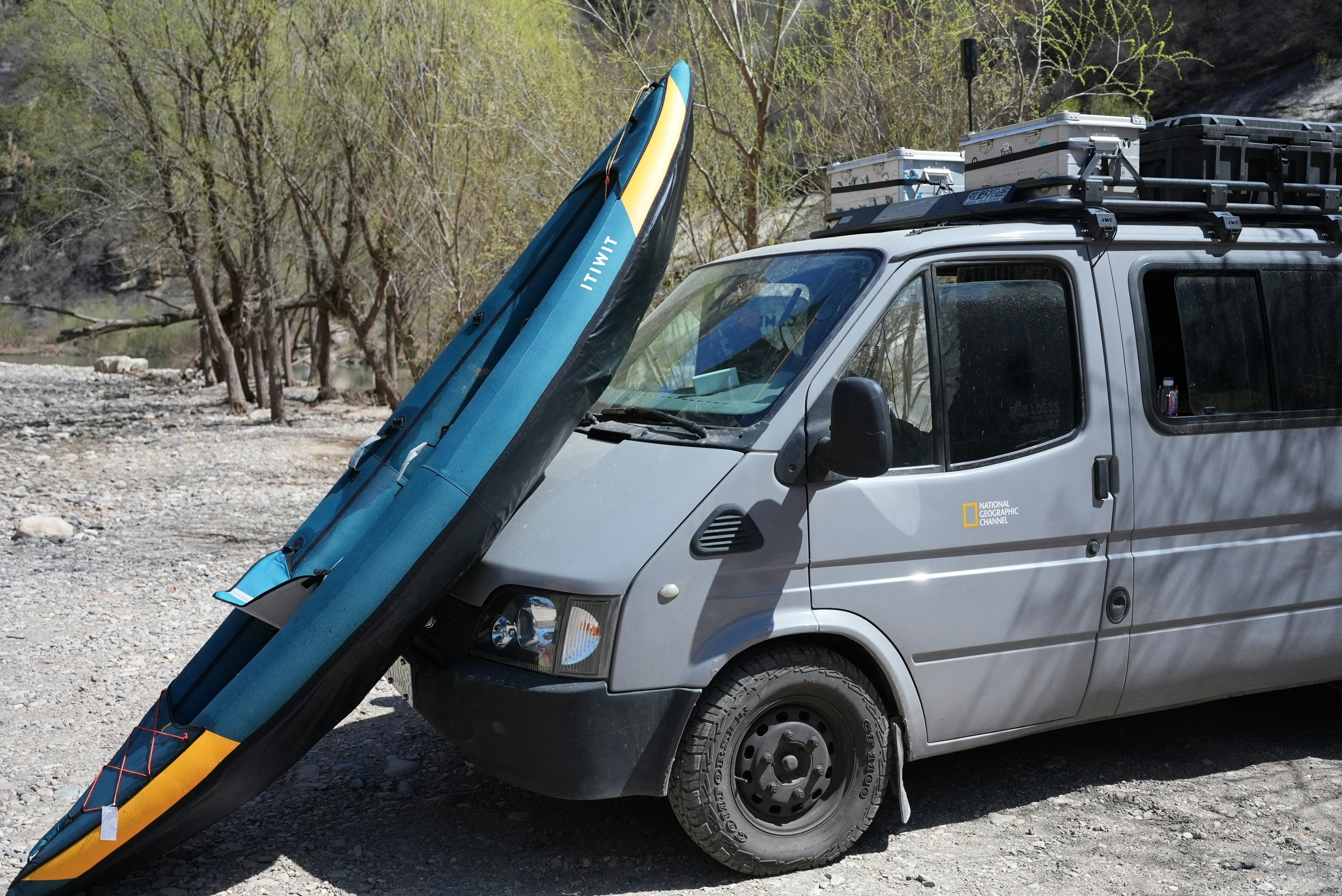 A kayak is leaning against a camper van