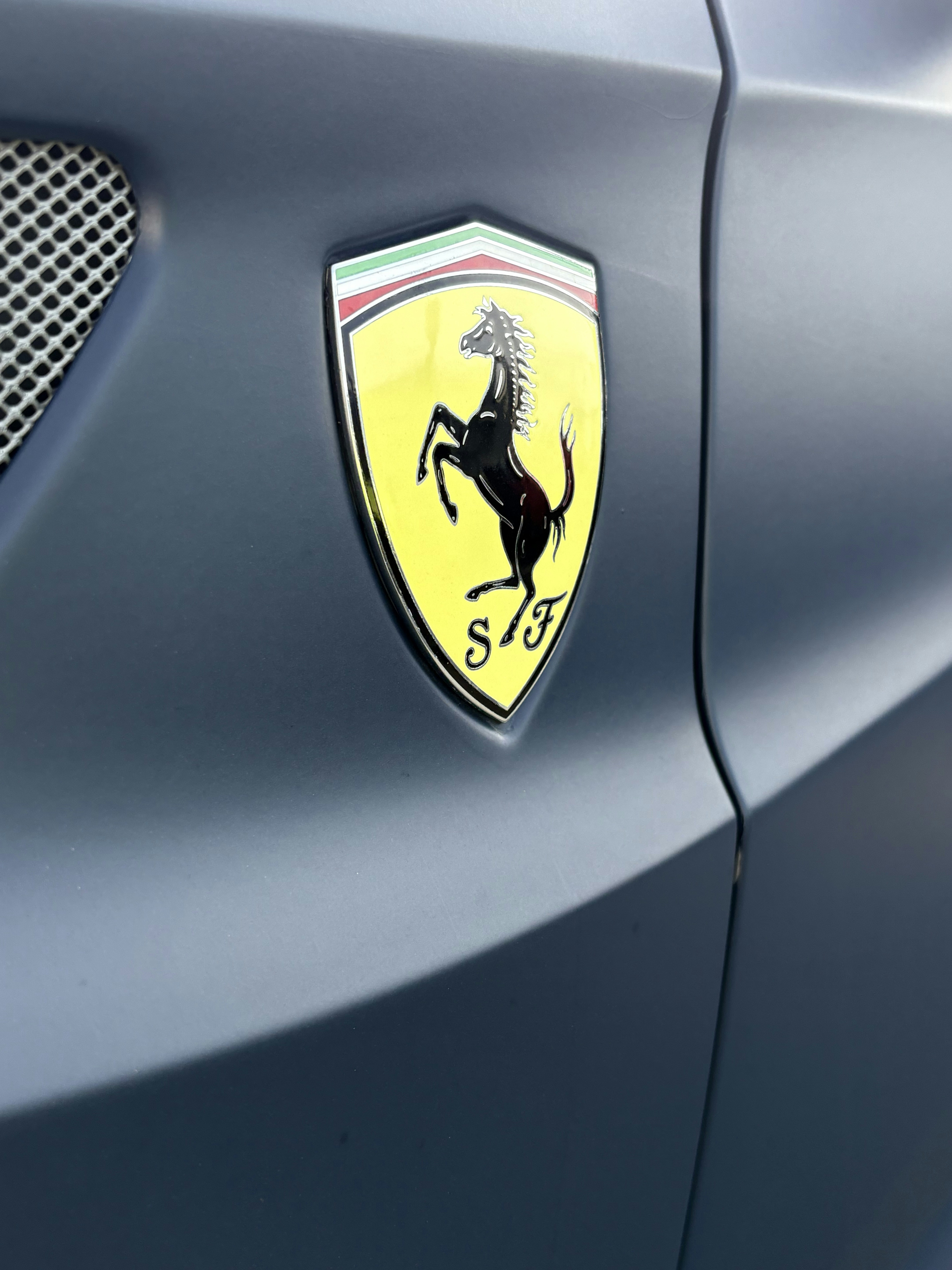 Ein Ferrari-Emblem ist auf einem Auto zu sehen.