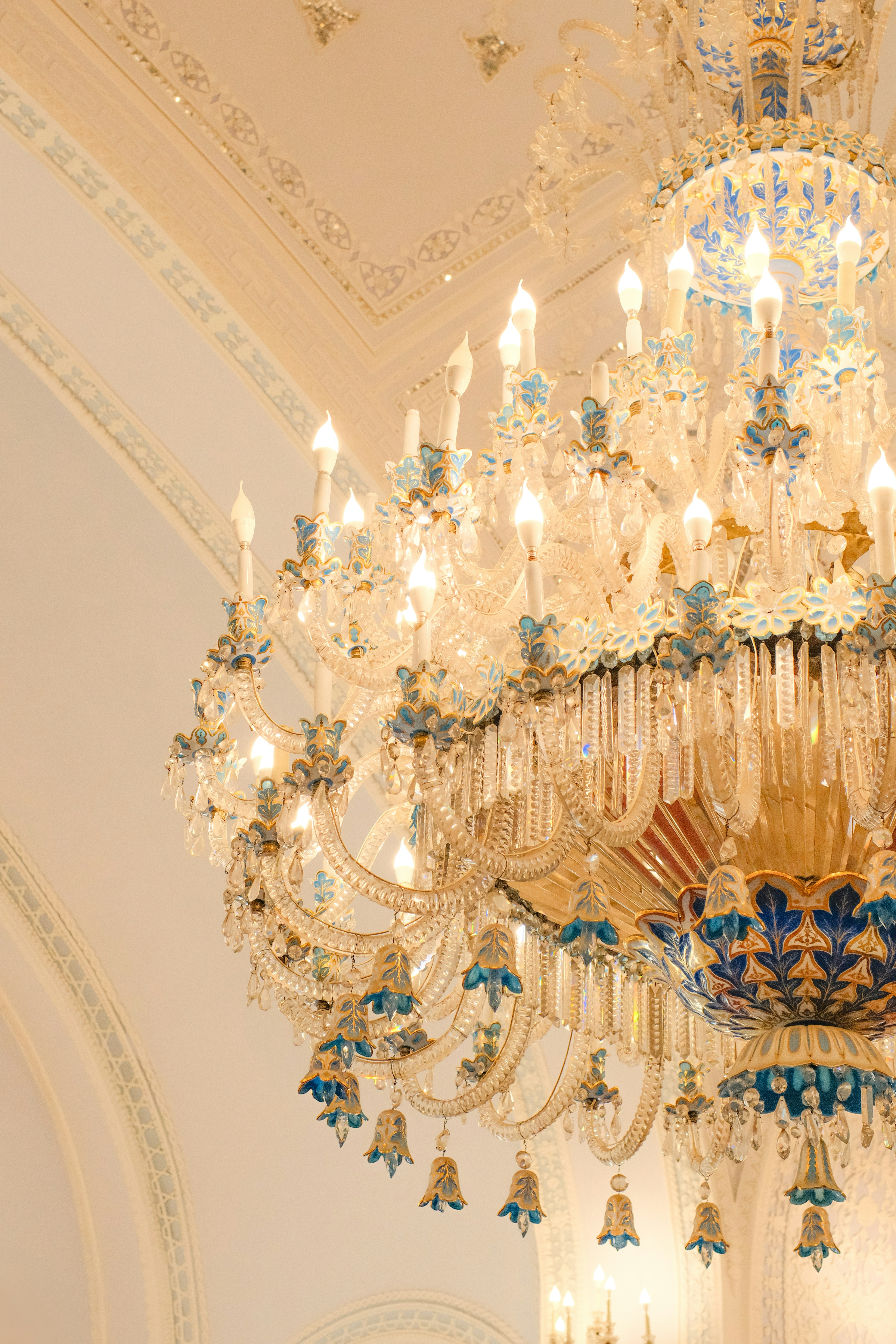 A stunning chandelier illuminates a white room.