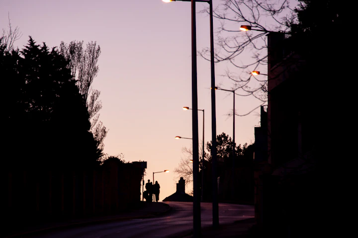 Streetlights lighting a road at dusk