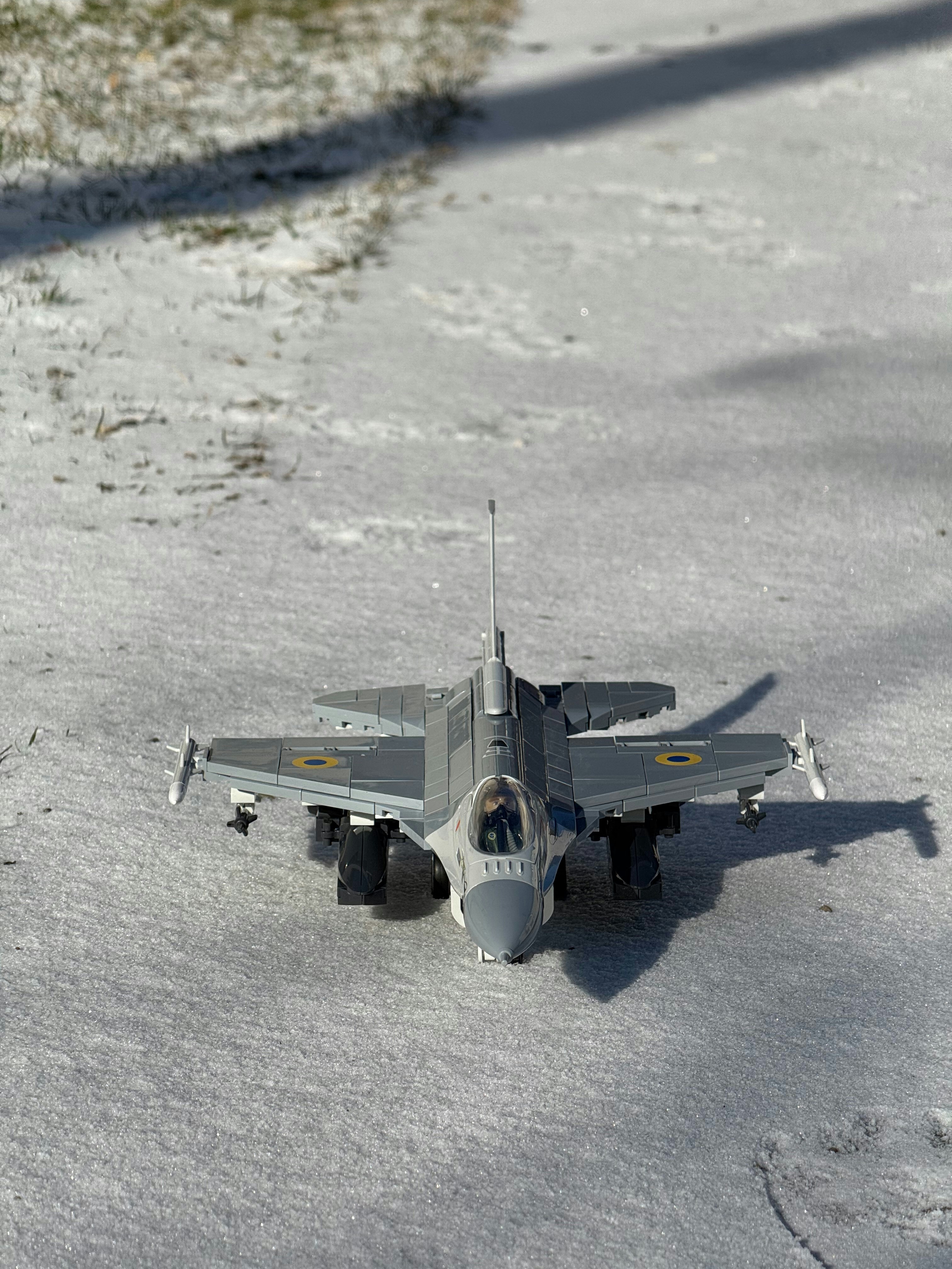 A toy airplane rests on snow.