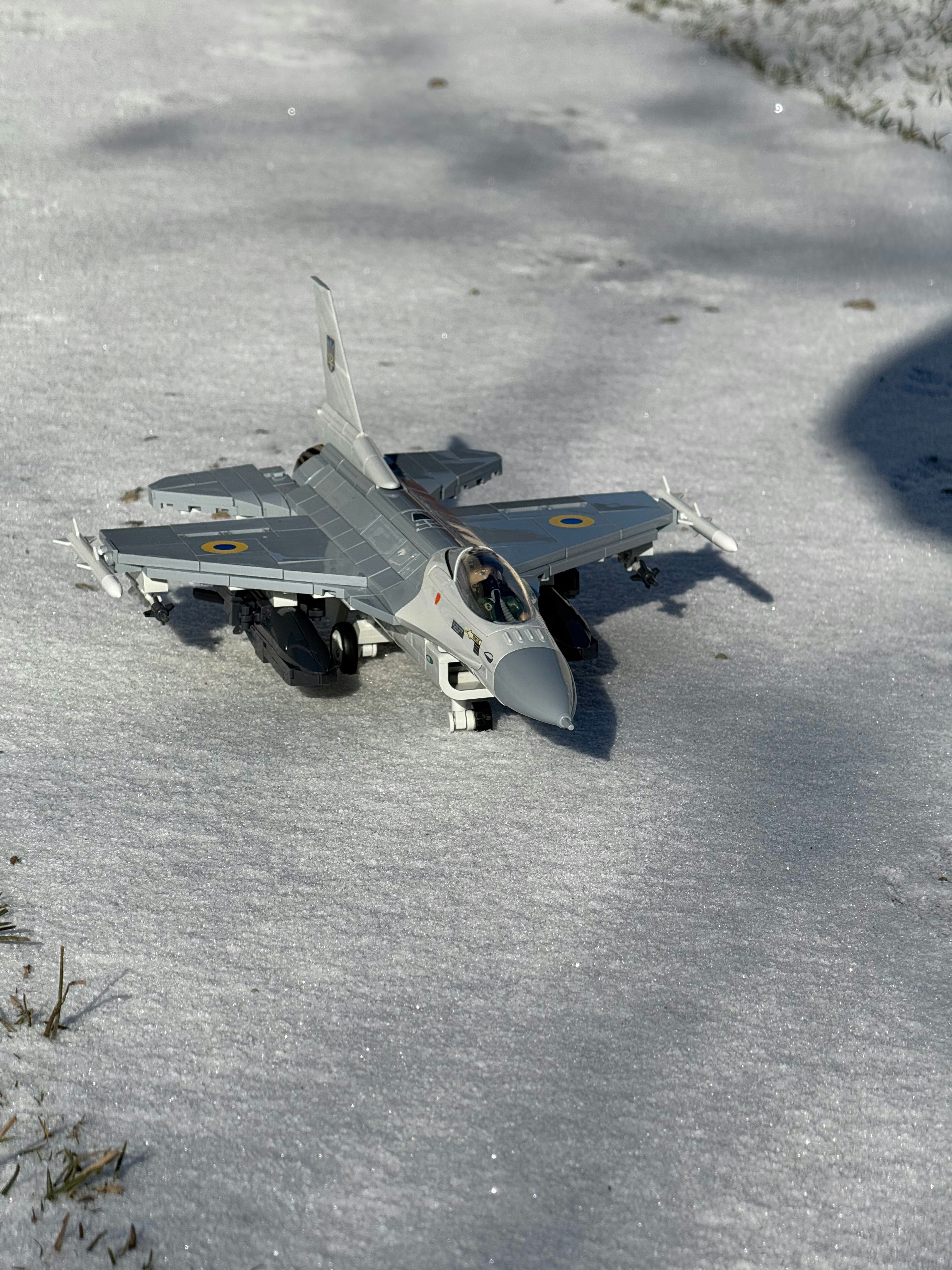 A toy airplane sits in the snow.