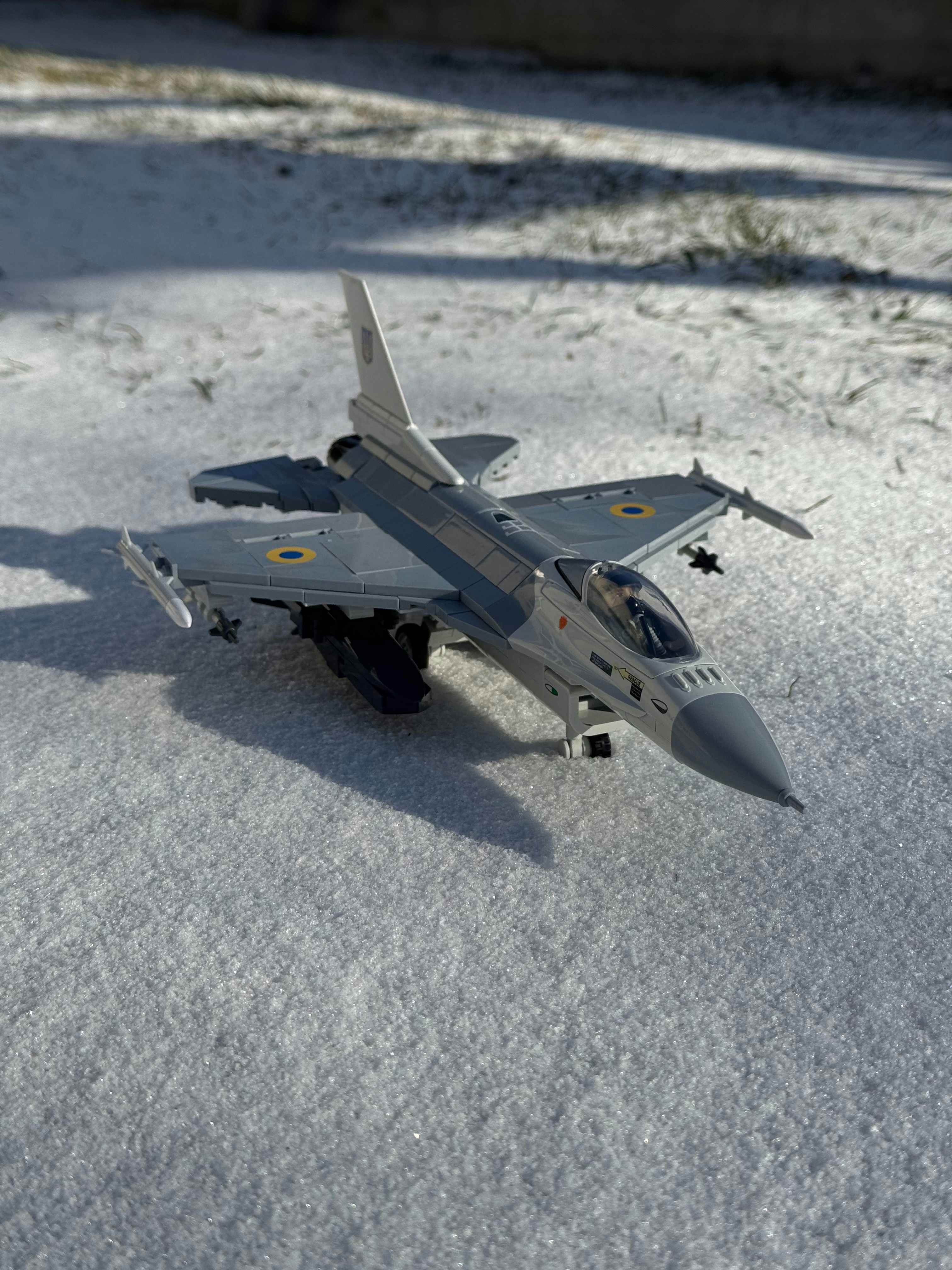 A toy airplane sits on snowy ground.