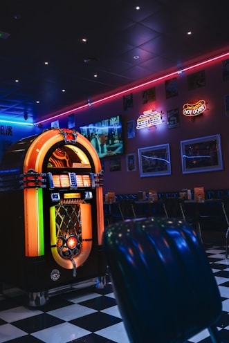 Retro diner interior with jukebox and neon lights.