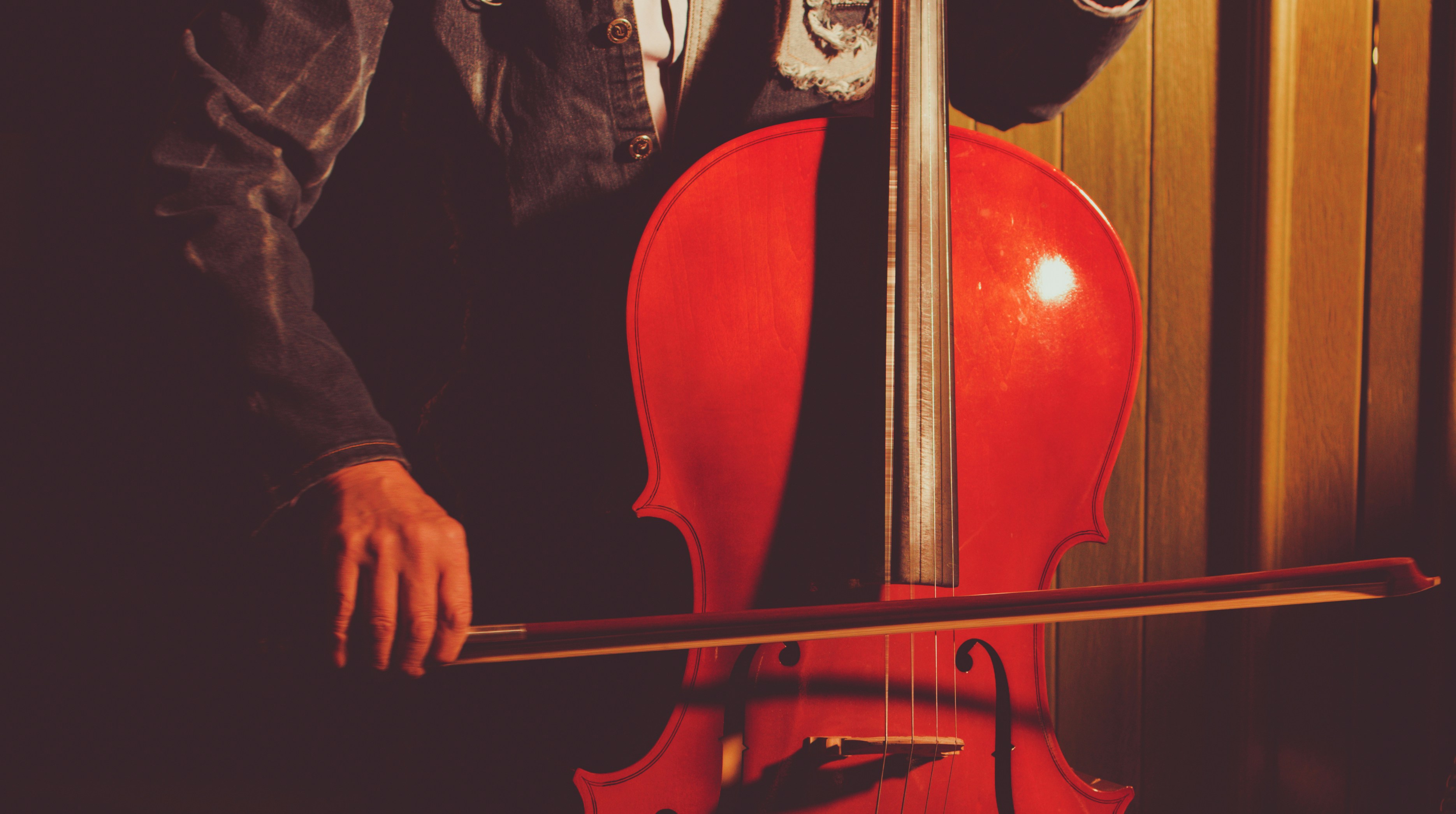 A person plays the cello with a bow.