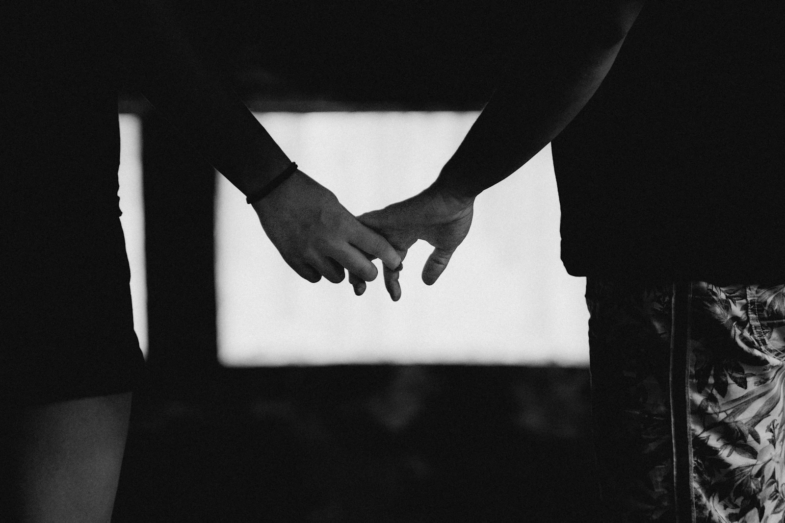Two people holding hands, close together