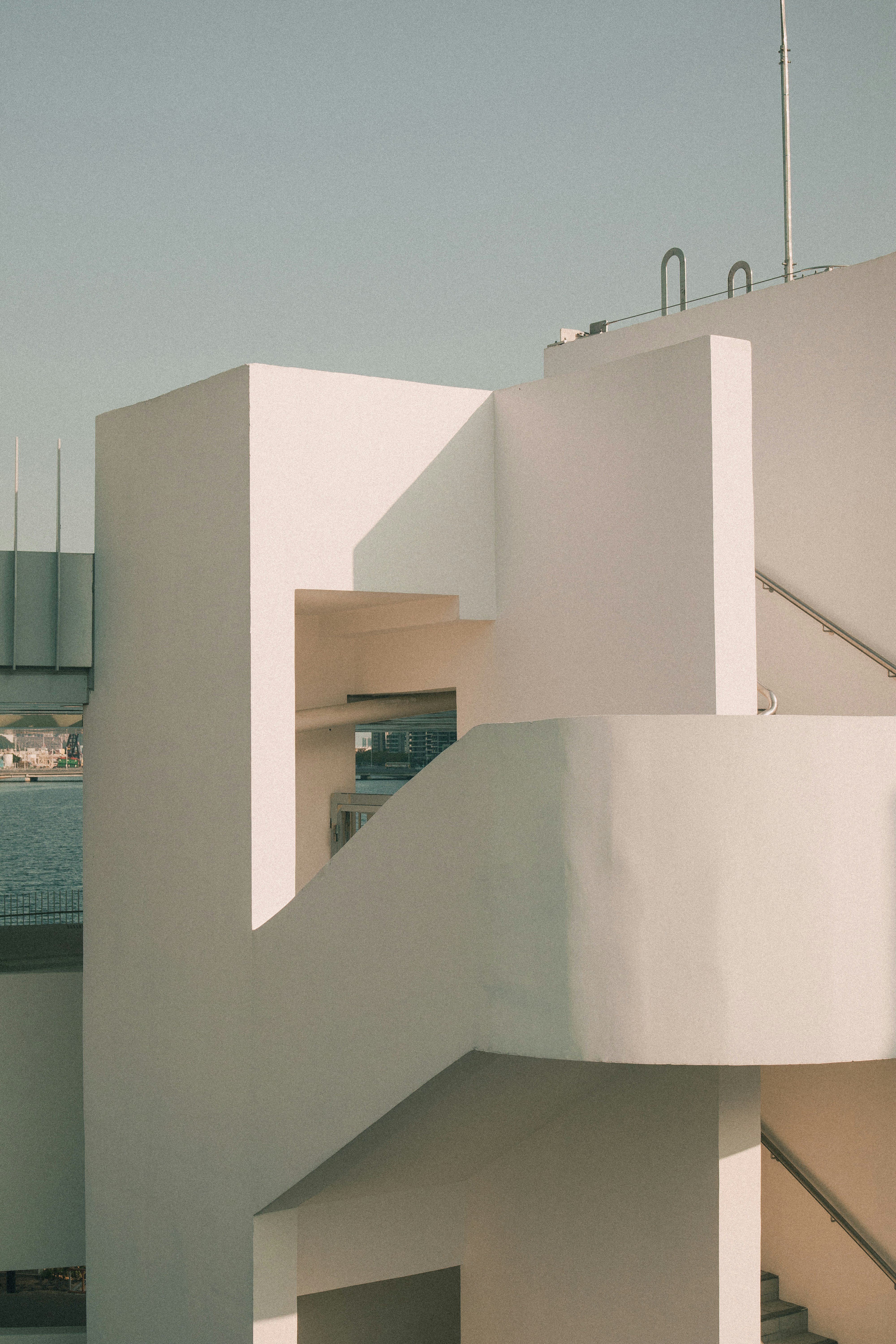 Minimalist architecture featuring stark white walls and stairs.