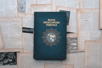 An encyclopedia lies surrounded by scattered papers.