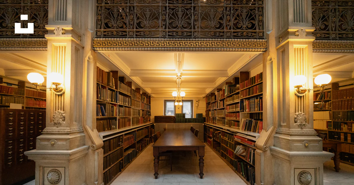 A library with books, tables, and pillars. photo – Free Architecture ...