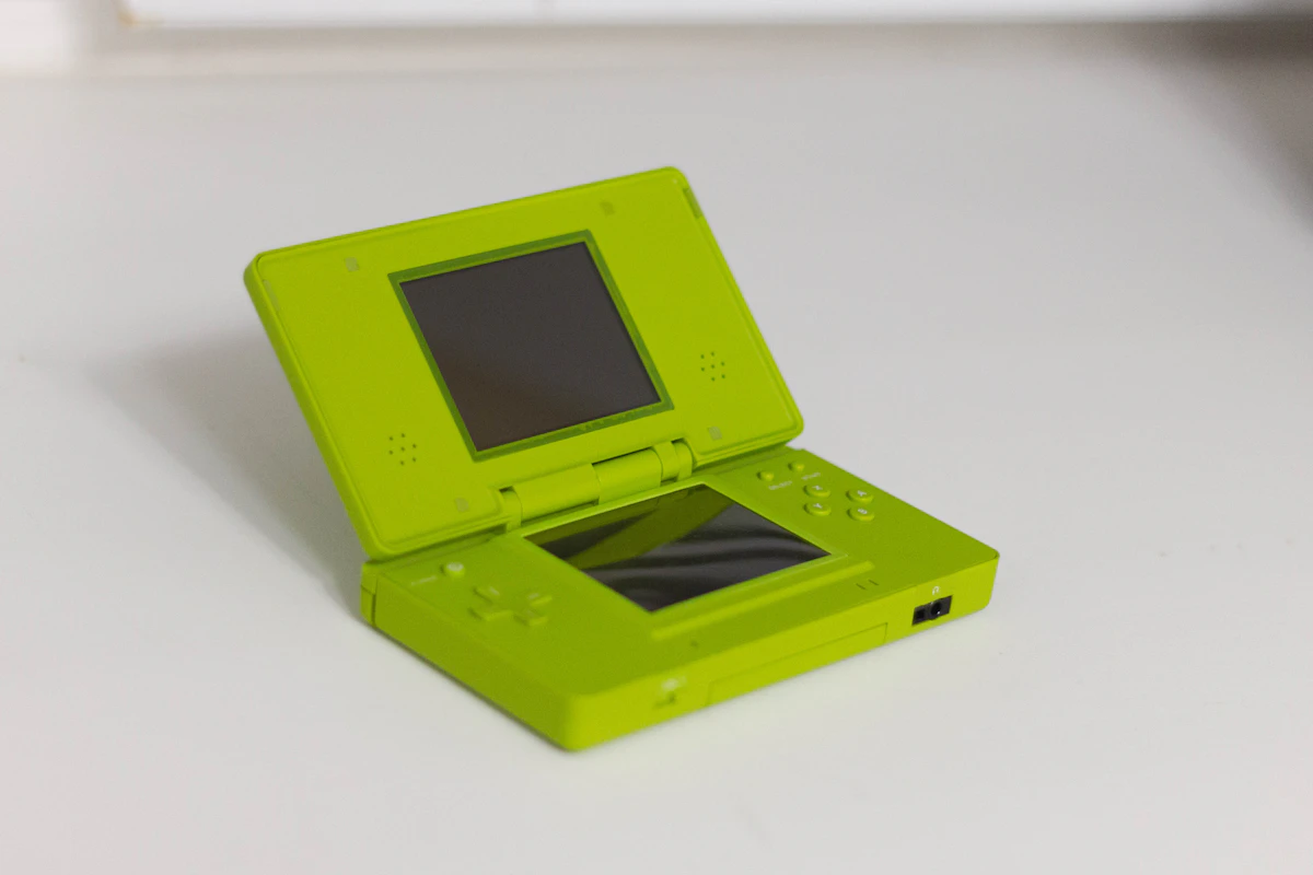 Lime green Nintendo DS photographed open on a white surface