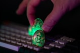 Hand placing glowing crypto coins on a keyboard.