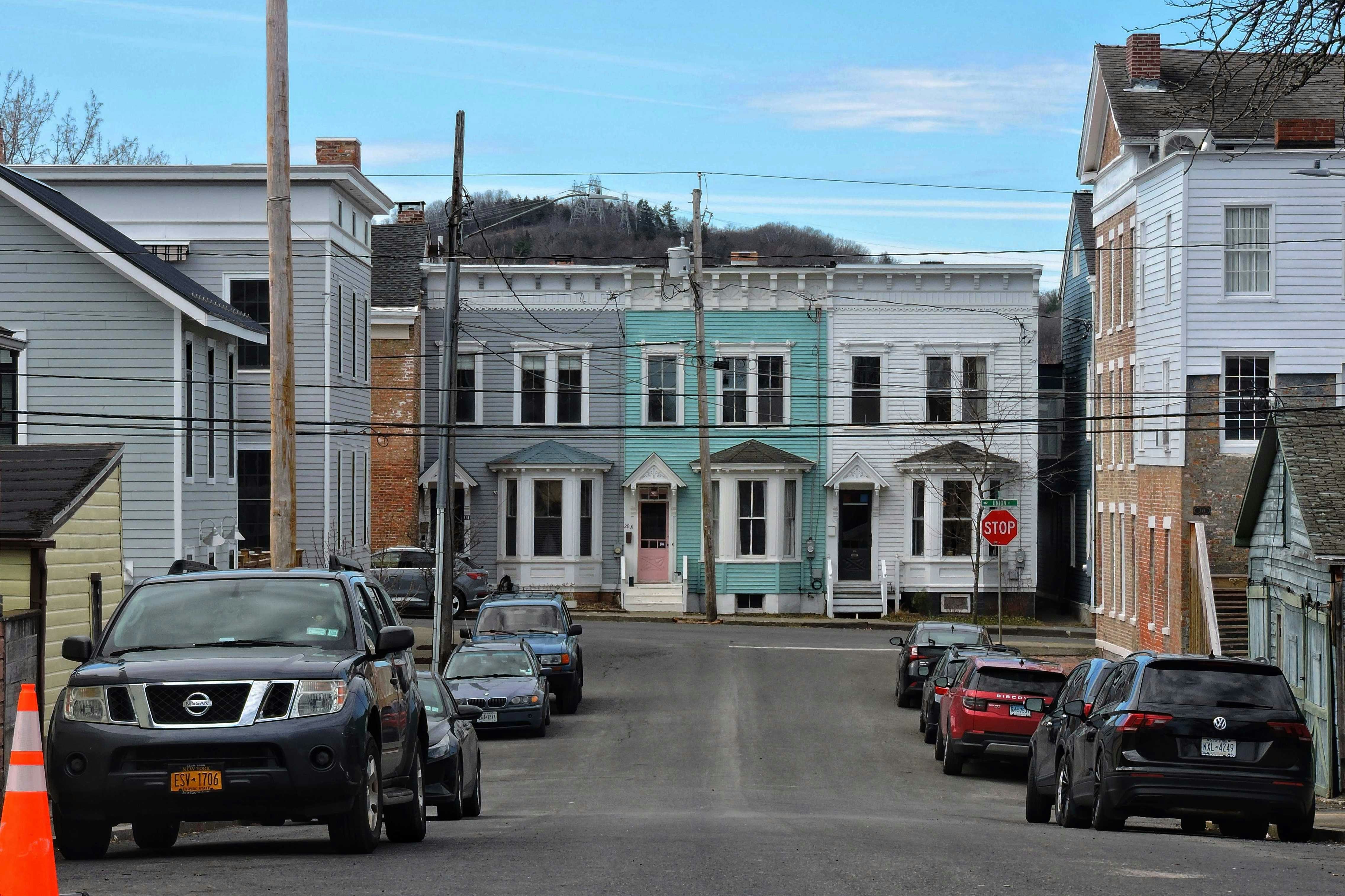 A residential street with various colored townhouses.