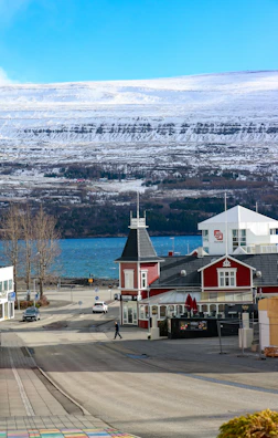 Red building by a road with snowy mountains