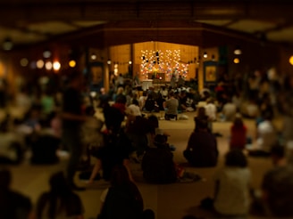 People meditate together inside a dimly lit hall.