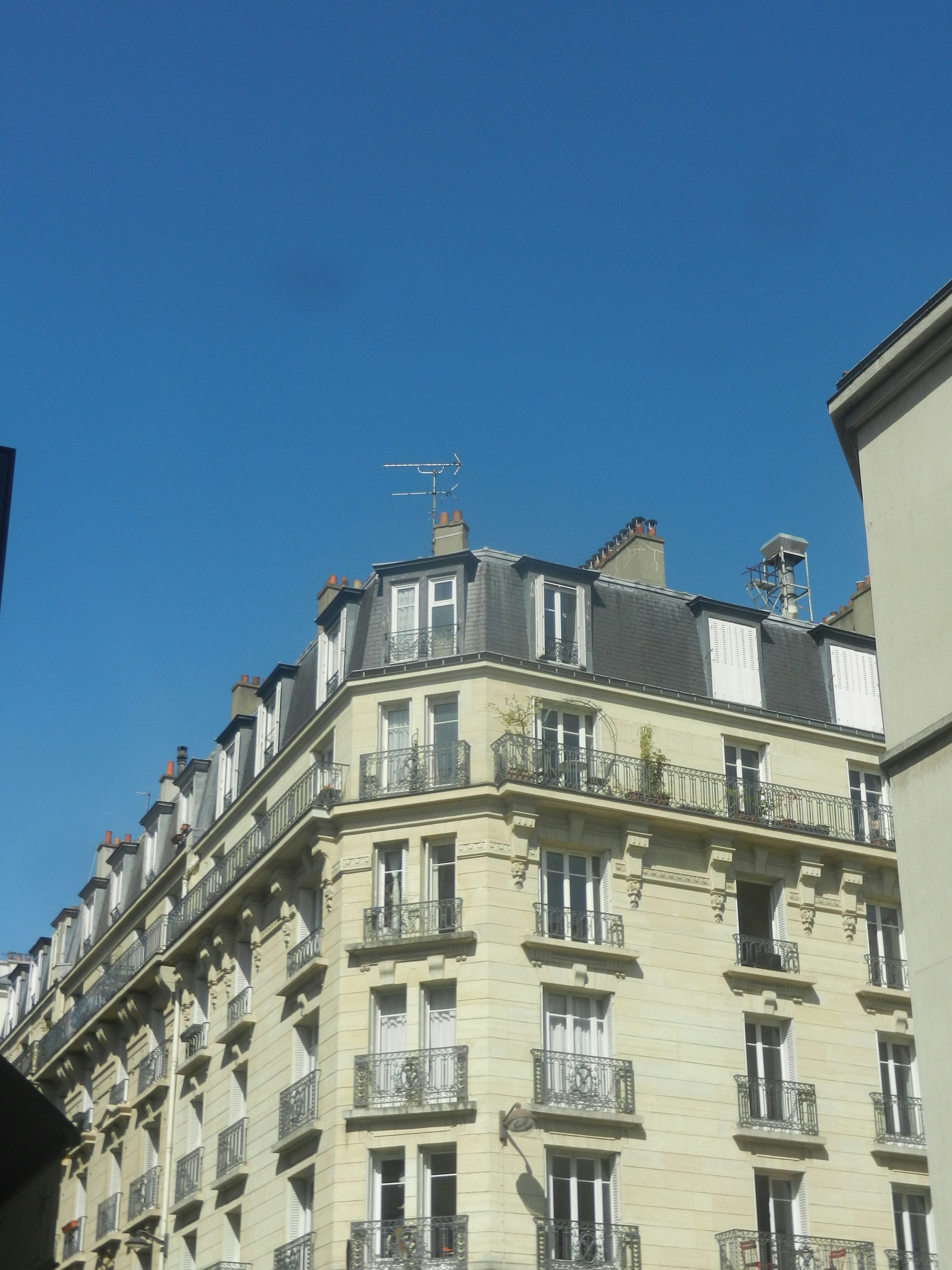 An elegant building stands against a vibrant blue sky.