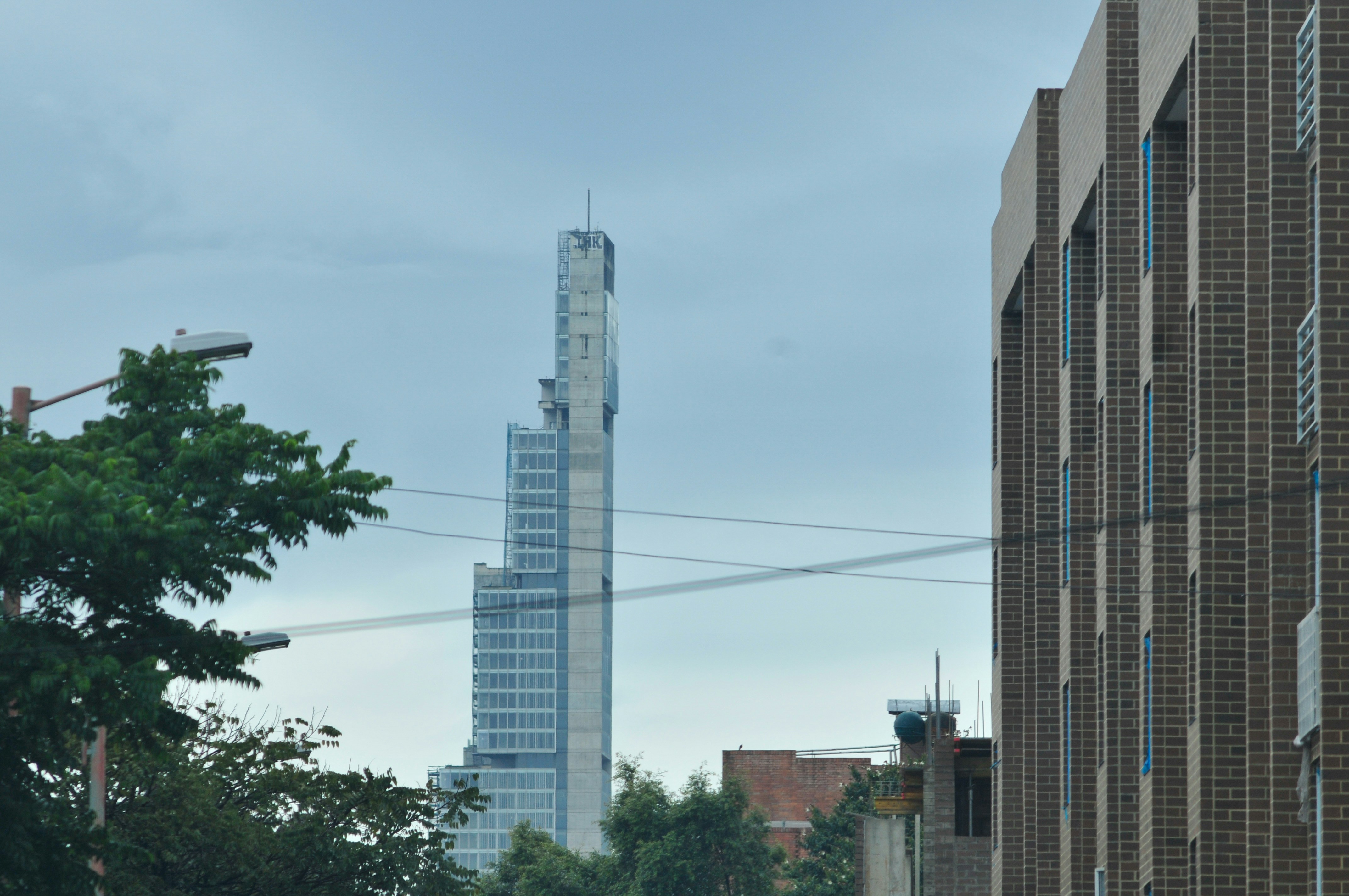 Un alto rascacielos se alza entre edificios.