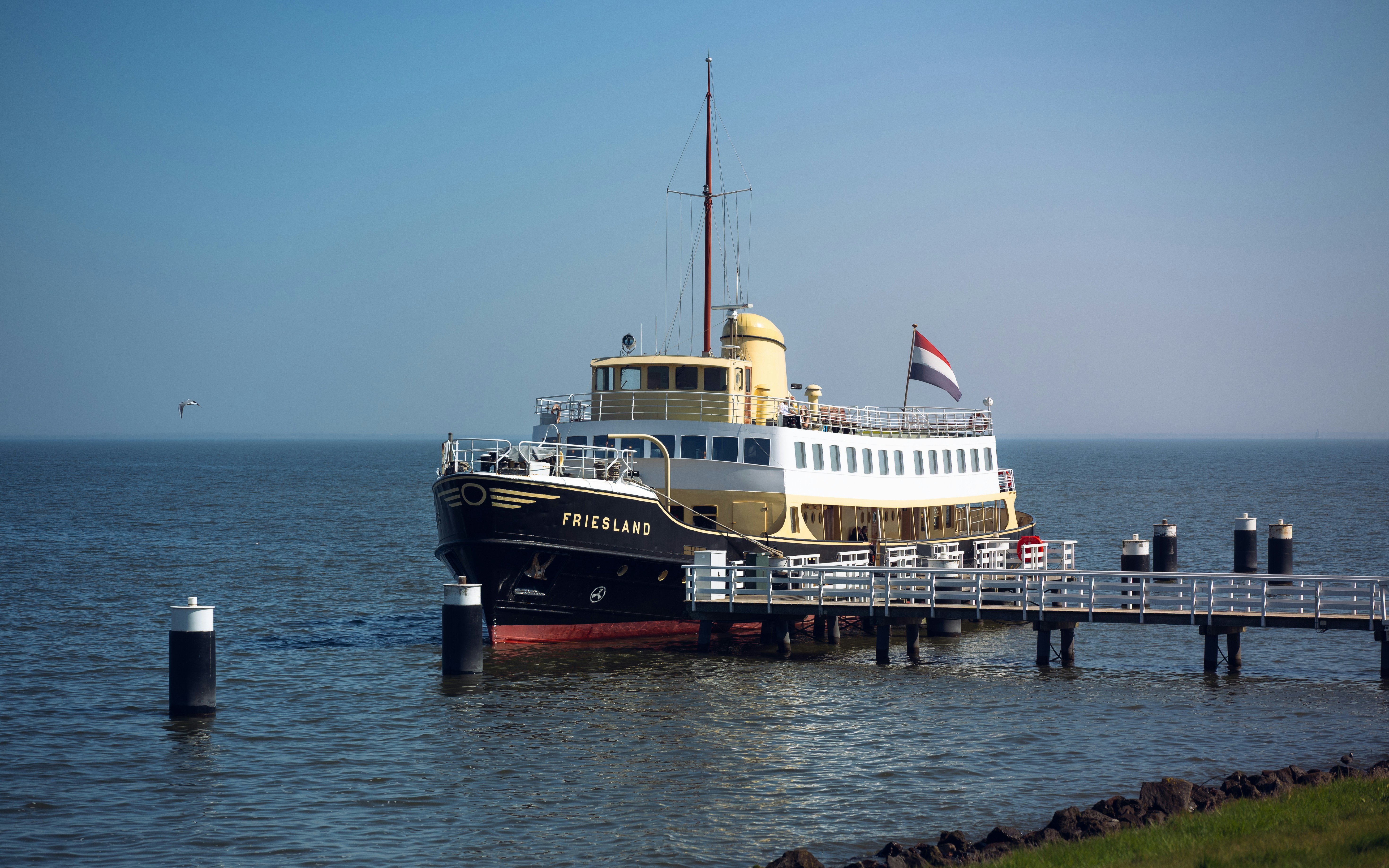 A ship docks at a pier on the water.