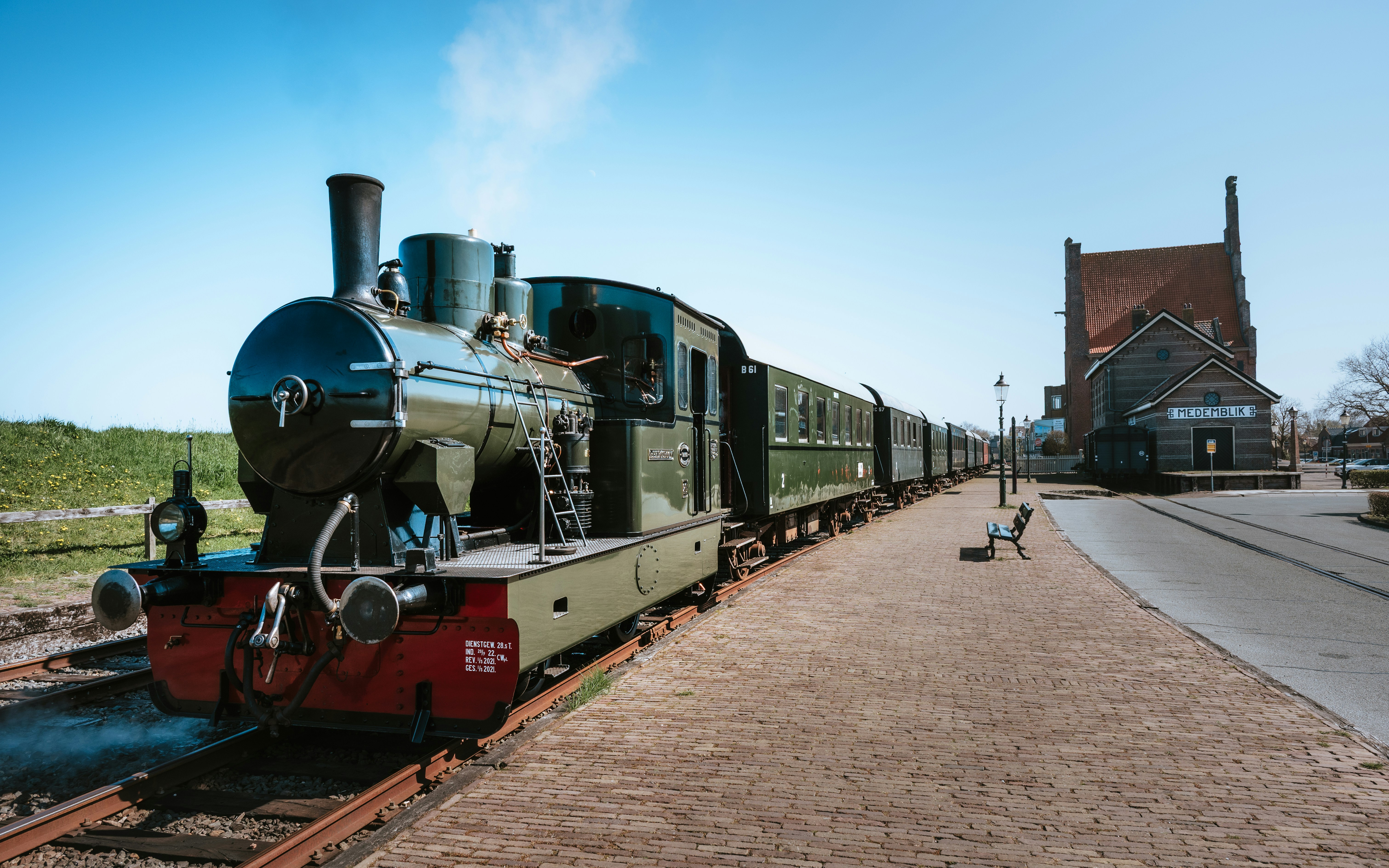 A steam train rolls along the tracks.