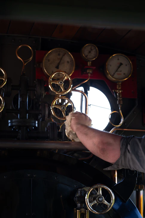 A man is working on the steam engine.