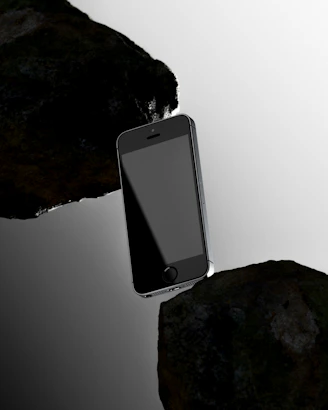 Smartphone suspended precariously between two rocks